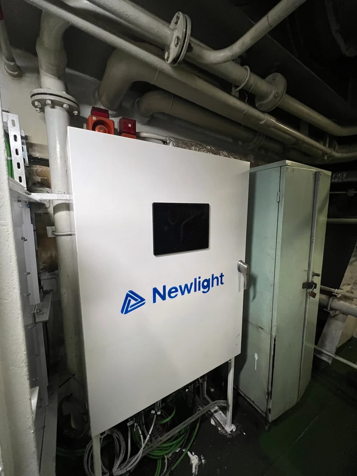 White Newlight control cabinet with a display installed in a vessel machinery room